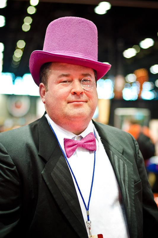 Cosplayer dressed as the Penguin from Batman in a purple top hat and monocle