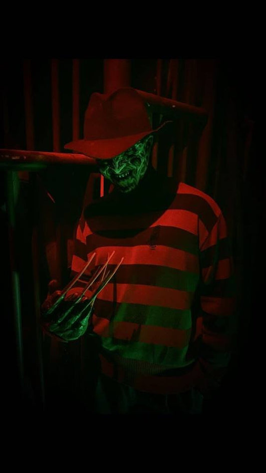 Cosplayer dressed as Freddy Krueger in his brown fedora and striped sweater