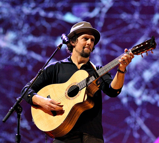Jason Mraz performing with a guitar in his signature tan short-brim trilby