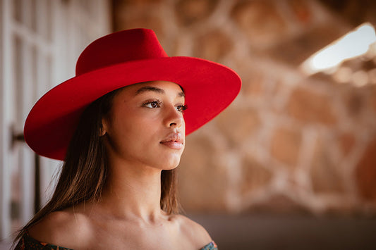 A woman wearing a wide-brim red fedora